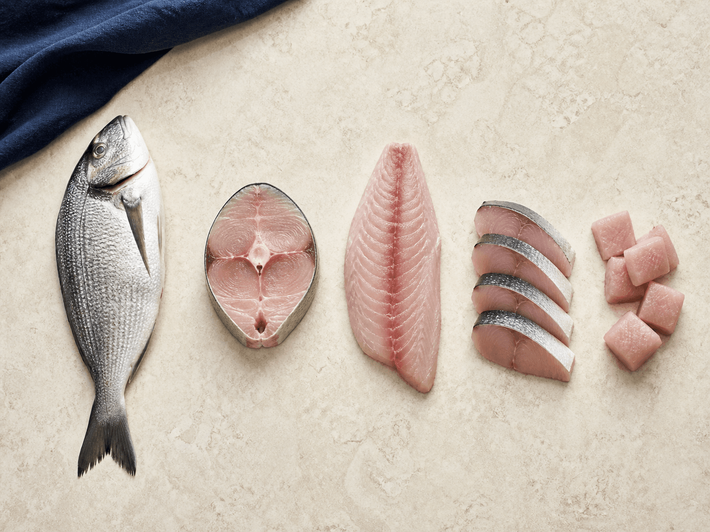 Whole fish, steaks, fillets and slices arranged for comparison